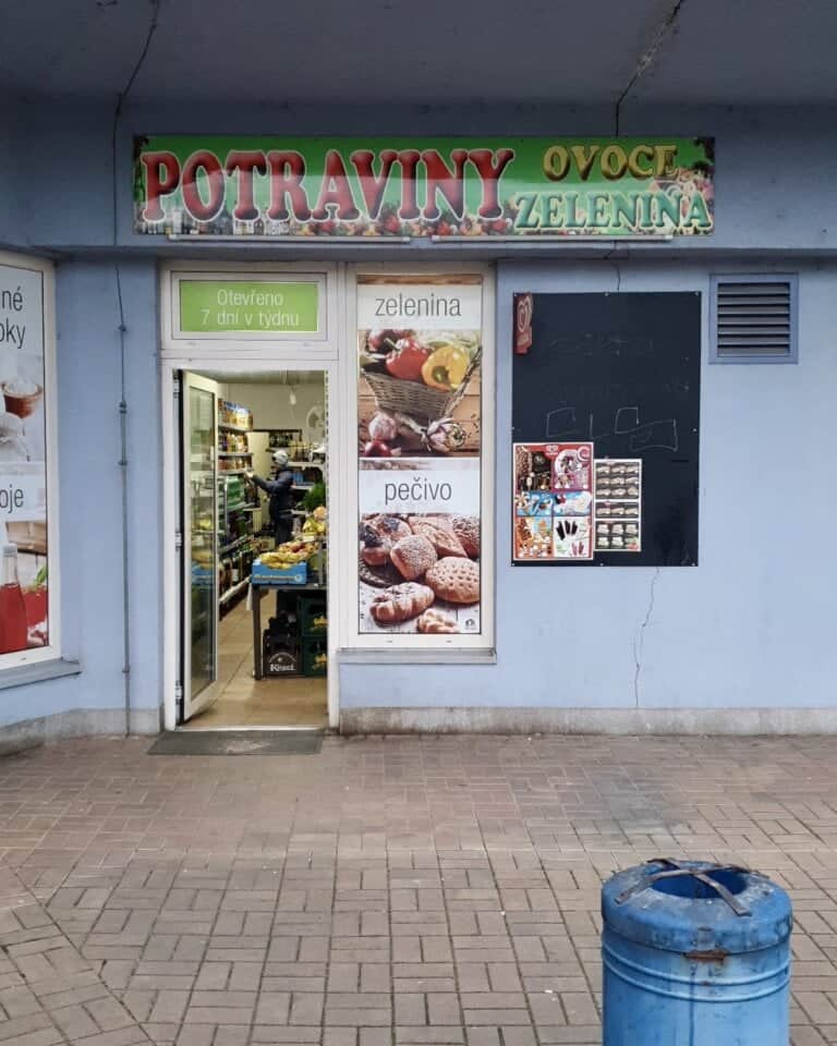 Grocery store entrance with fruit and vegetable signage.
