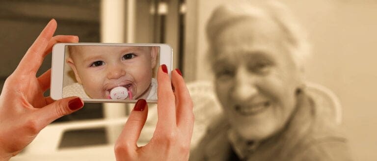 Smartphone showing baby photo to elderly woman.