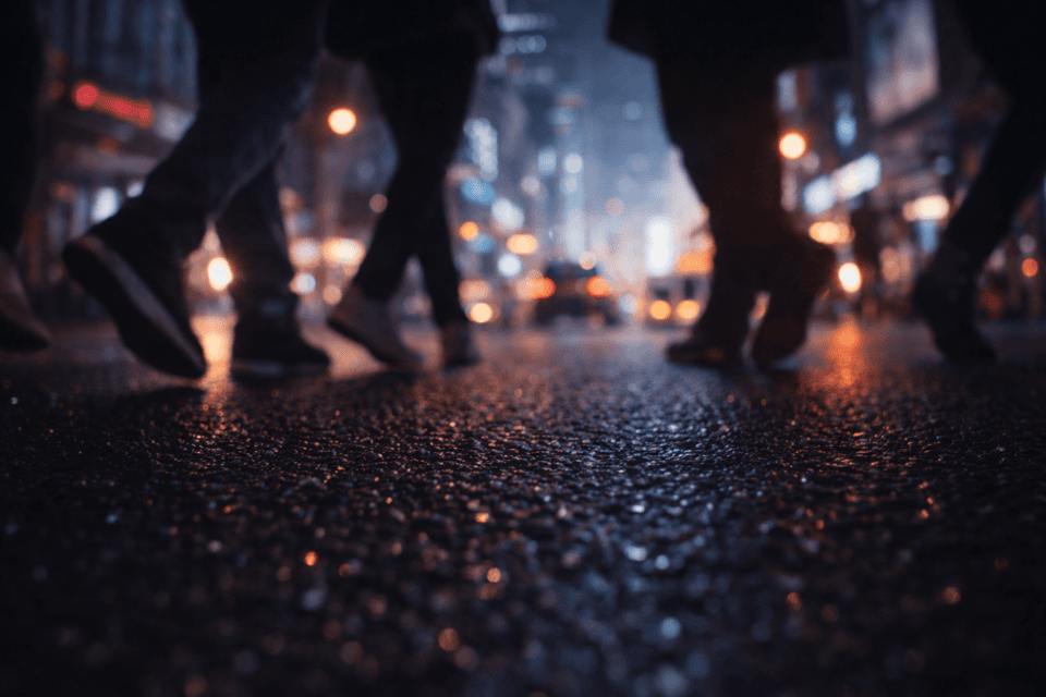 Pedestrians walking on wet city street at night